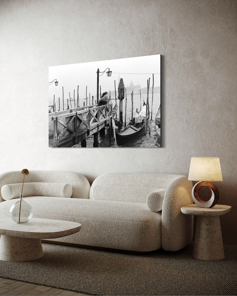Zwart-wit fotografie op canvas van een stel dat elkaar omhelst op een steiger in Venetië, met gondels, water en een mistige stadsomgeving.